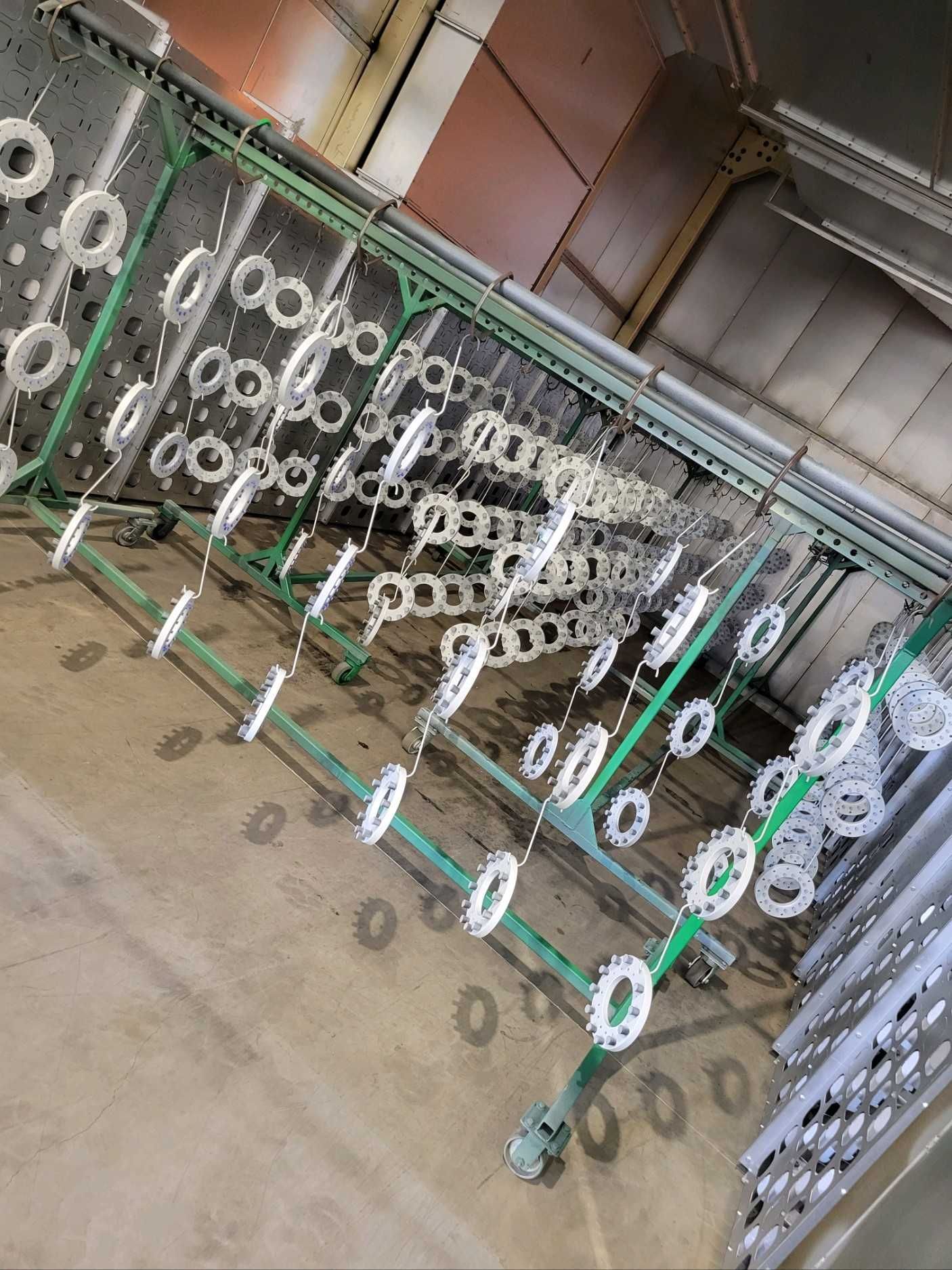 A bunch of metal parts are hanging on a conveyor belt in a factory.