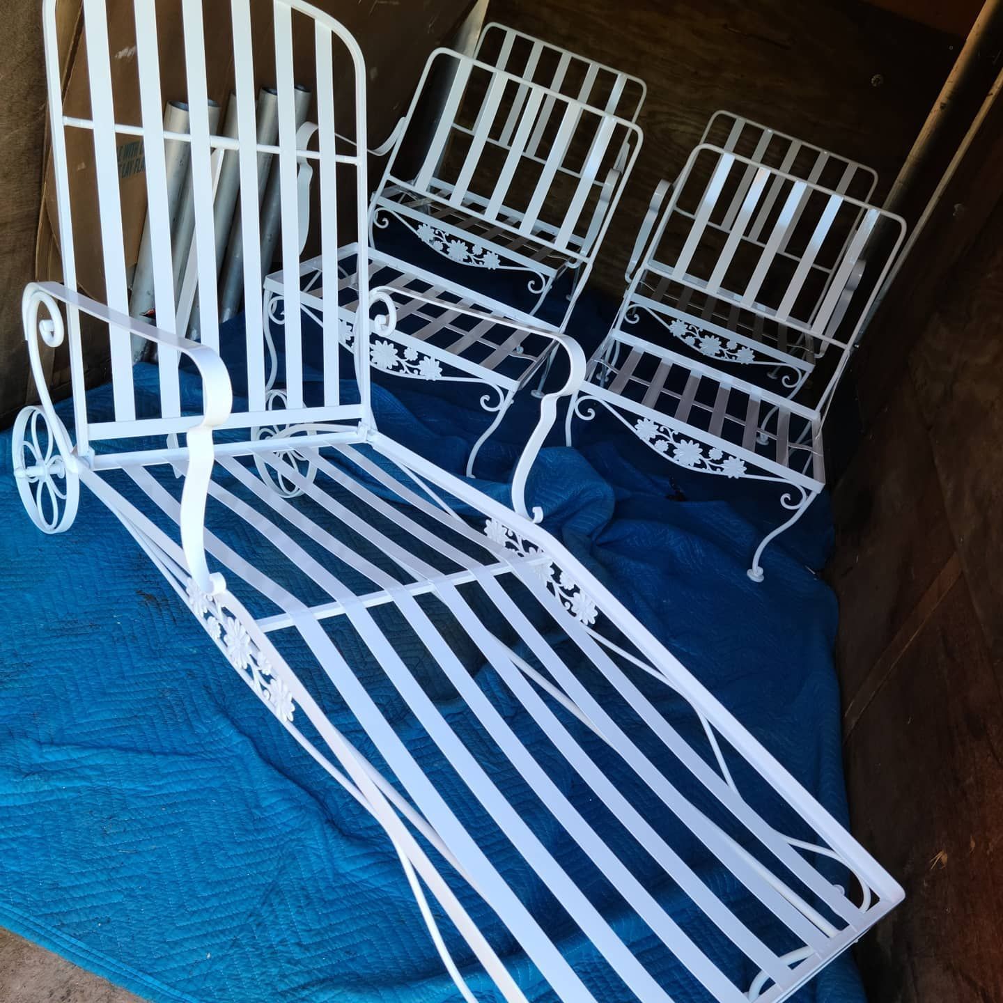 Three white chairs are sitting on a blue blanket