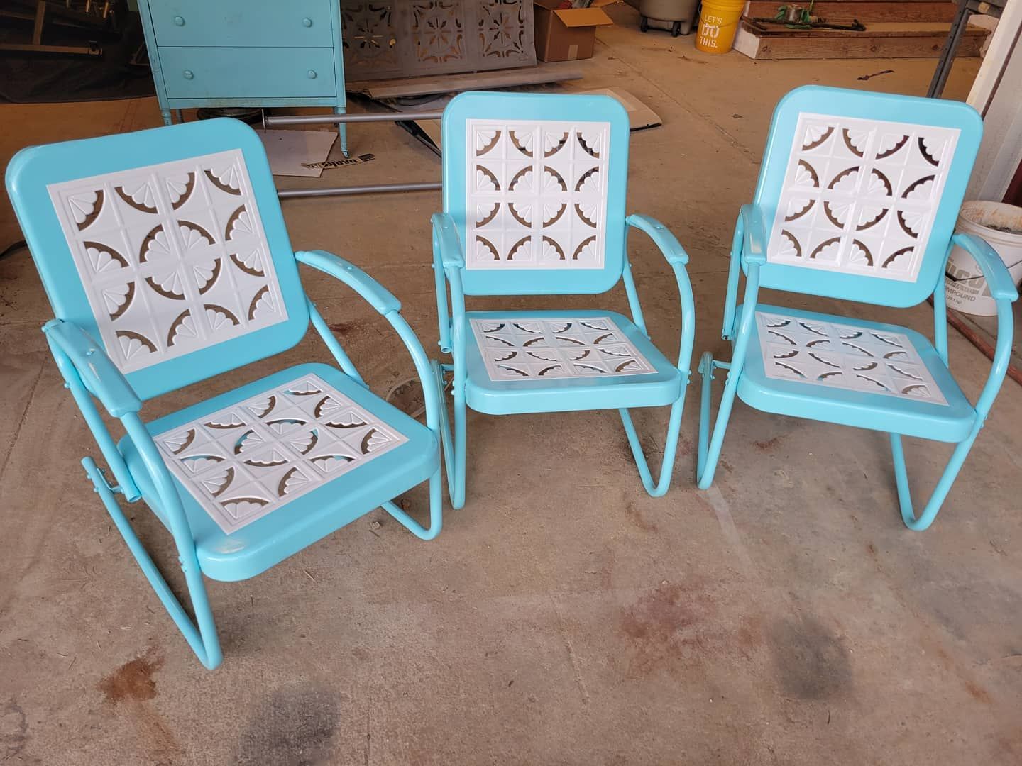 Three blue chairs are sitting on a cement floor