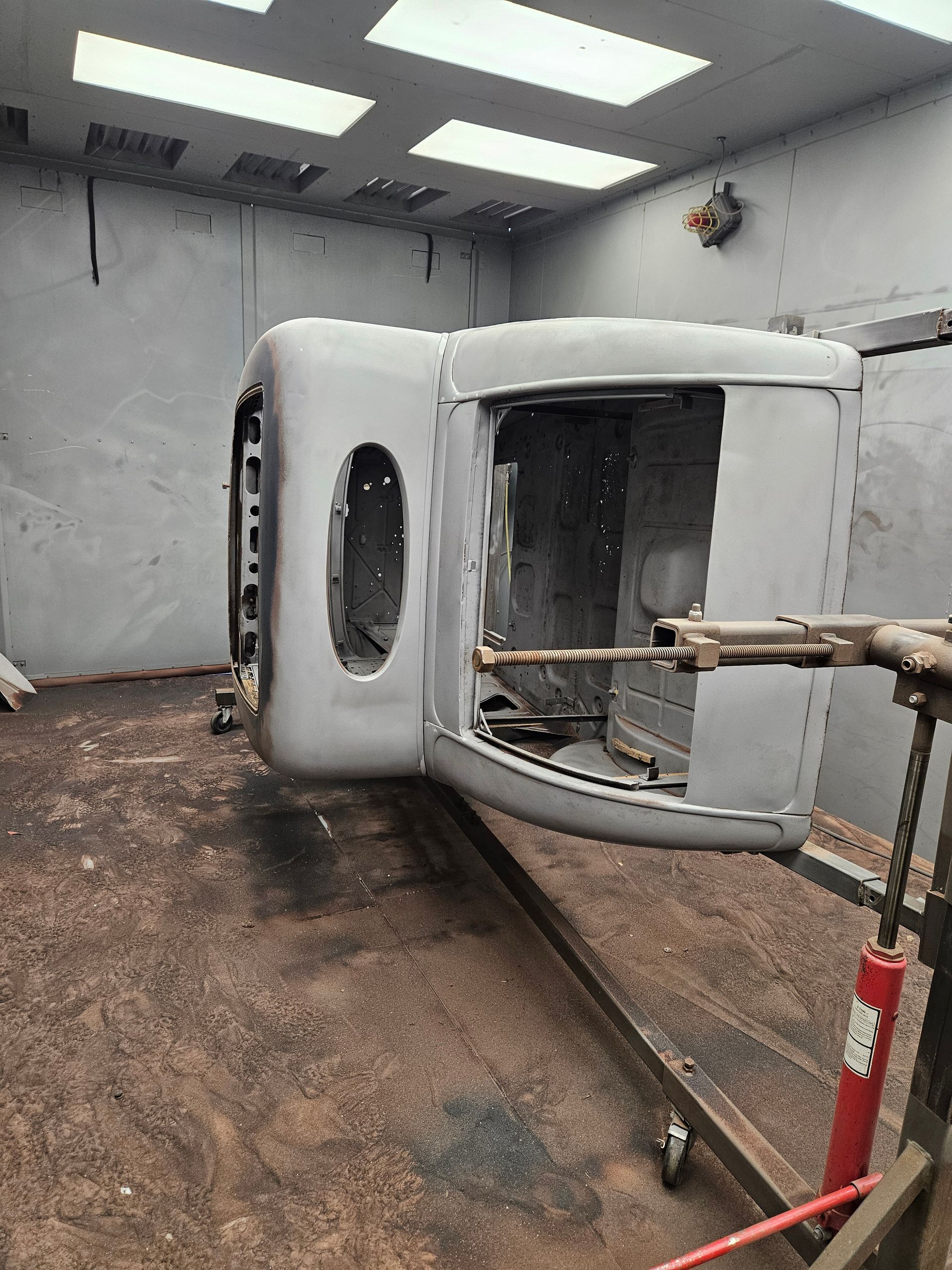 A car is being painted in a paint booth.