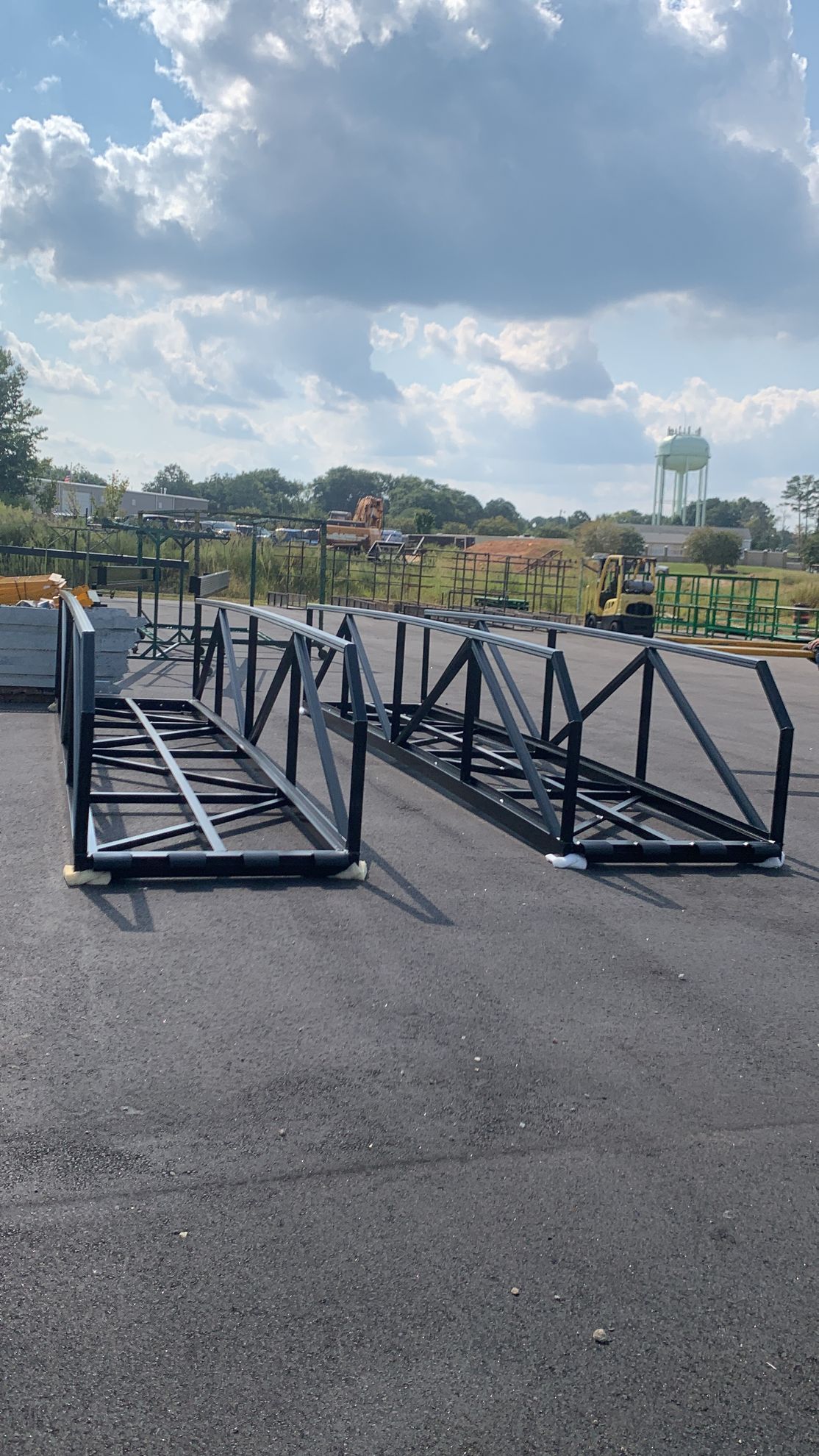 A bunch of metal frames are sitting on the ground in a parking lot.