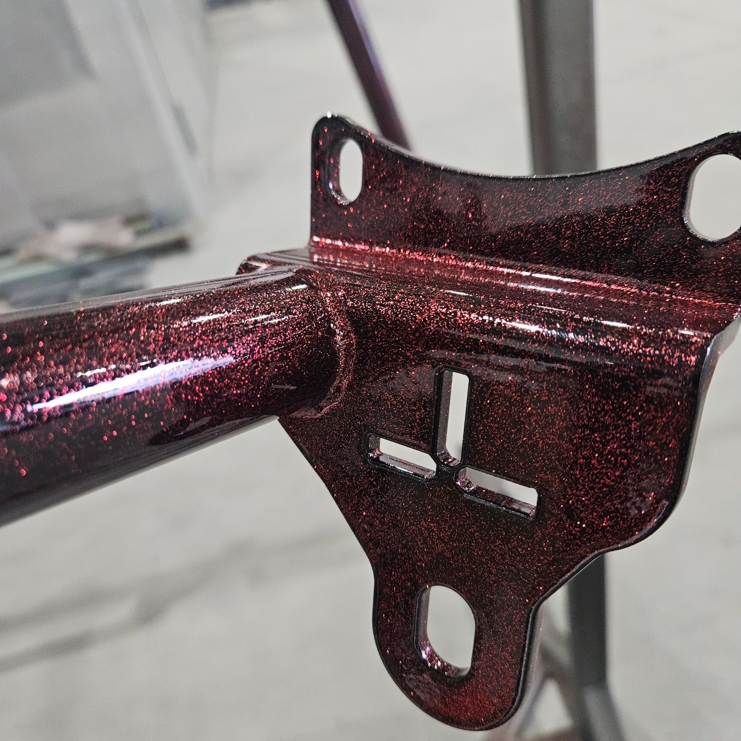 A close up of a red metal object with holes in it