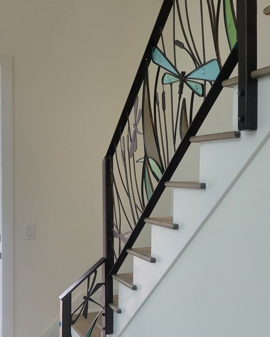 A staircase with a dragonfly design on the railing