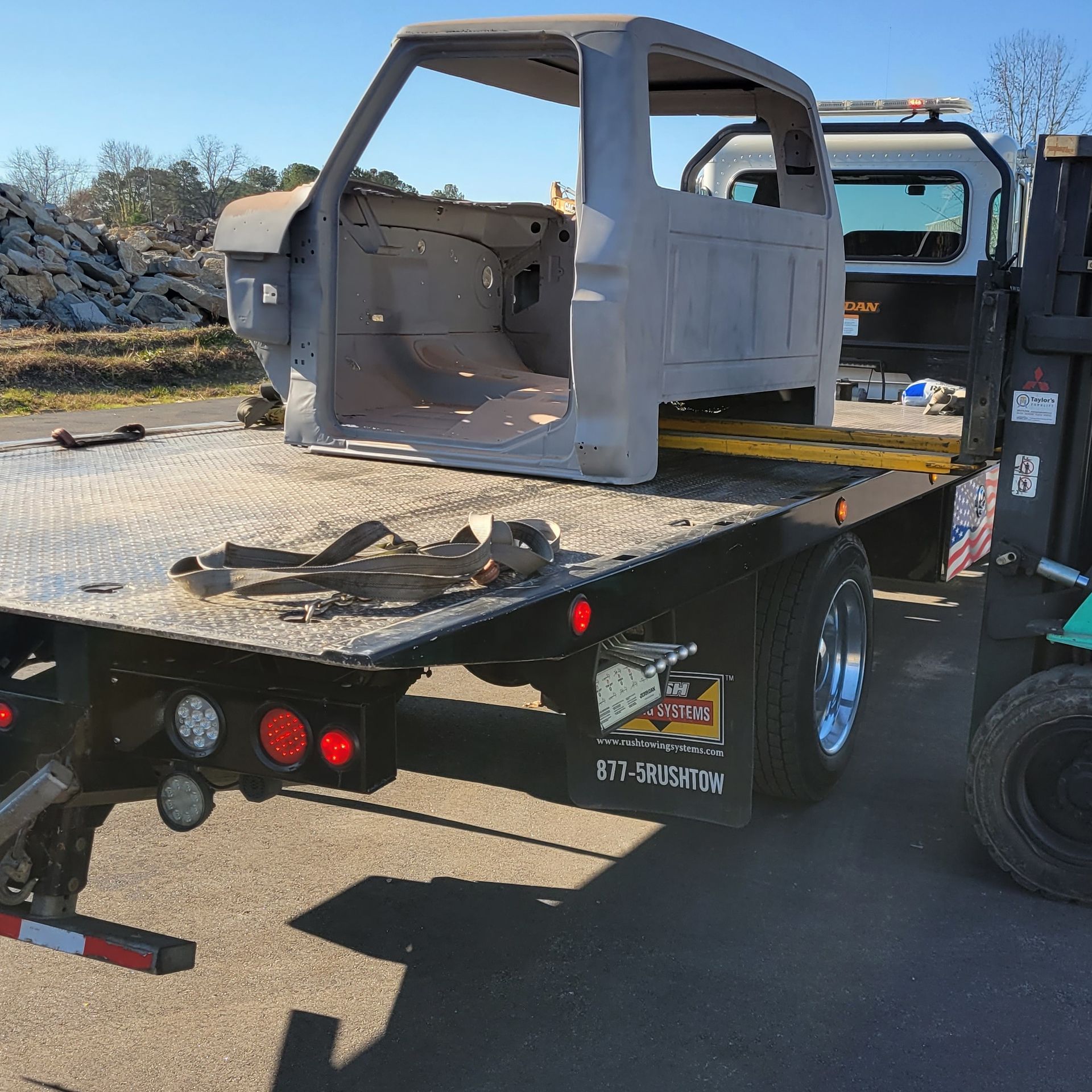 A tow truck with a forklift attached to it