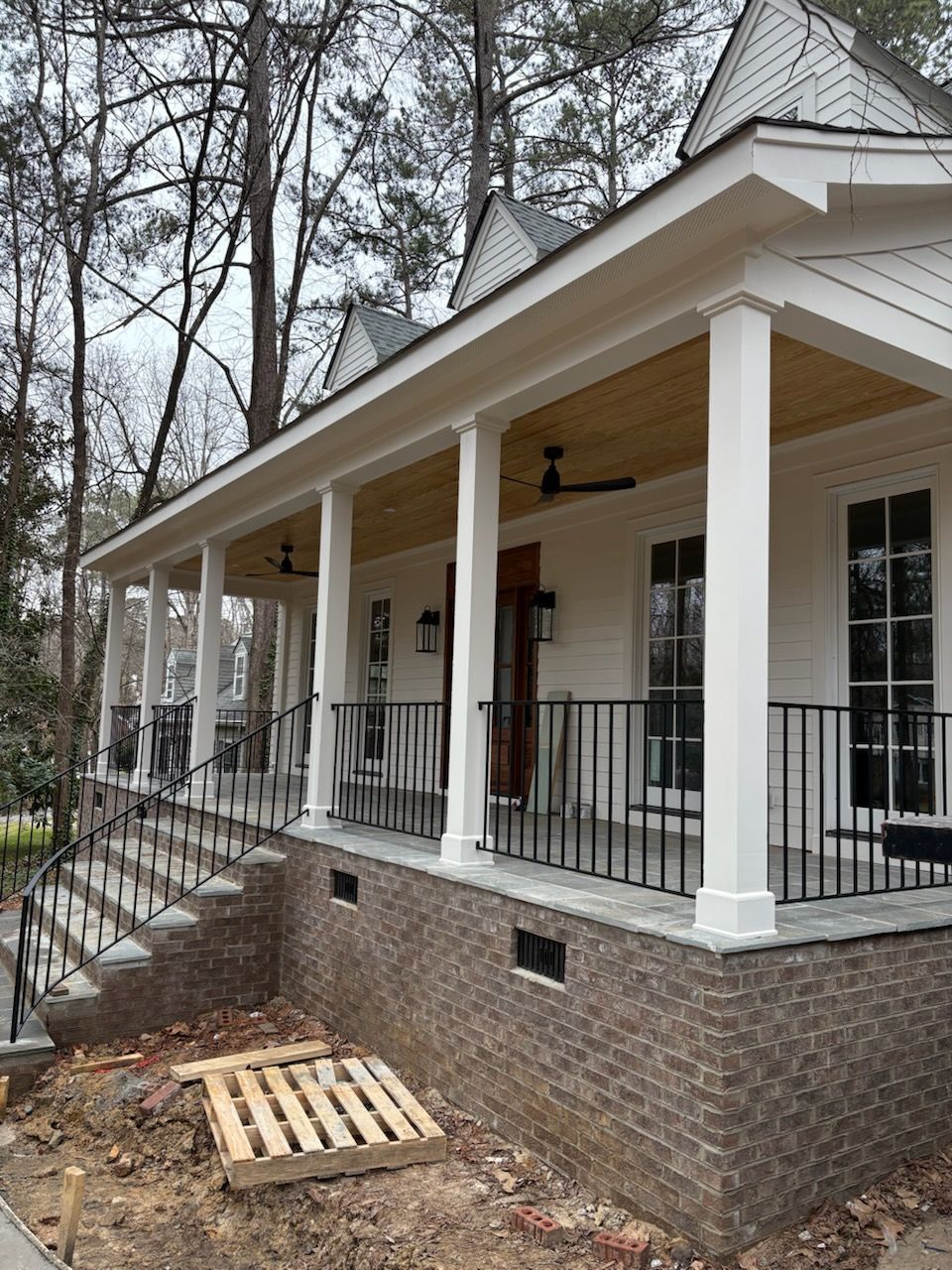 A white house with a large porch and stairs