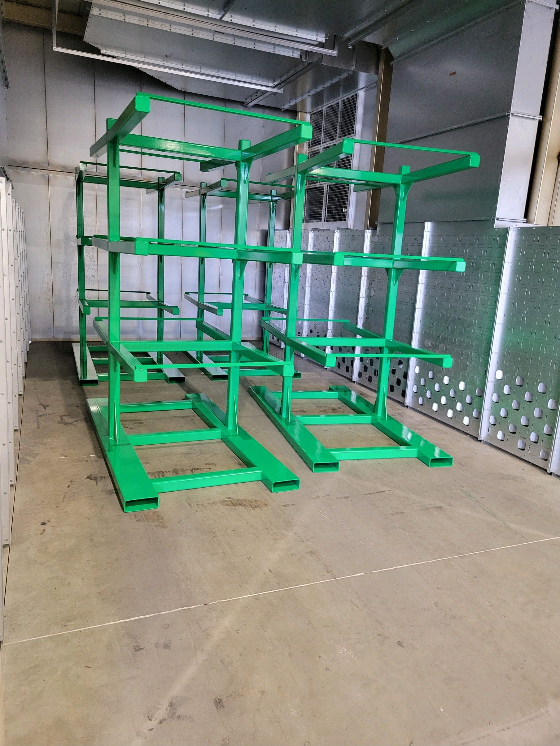 A row of green metal shelves in a warehouse