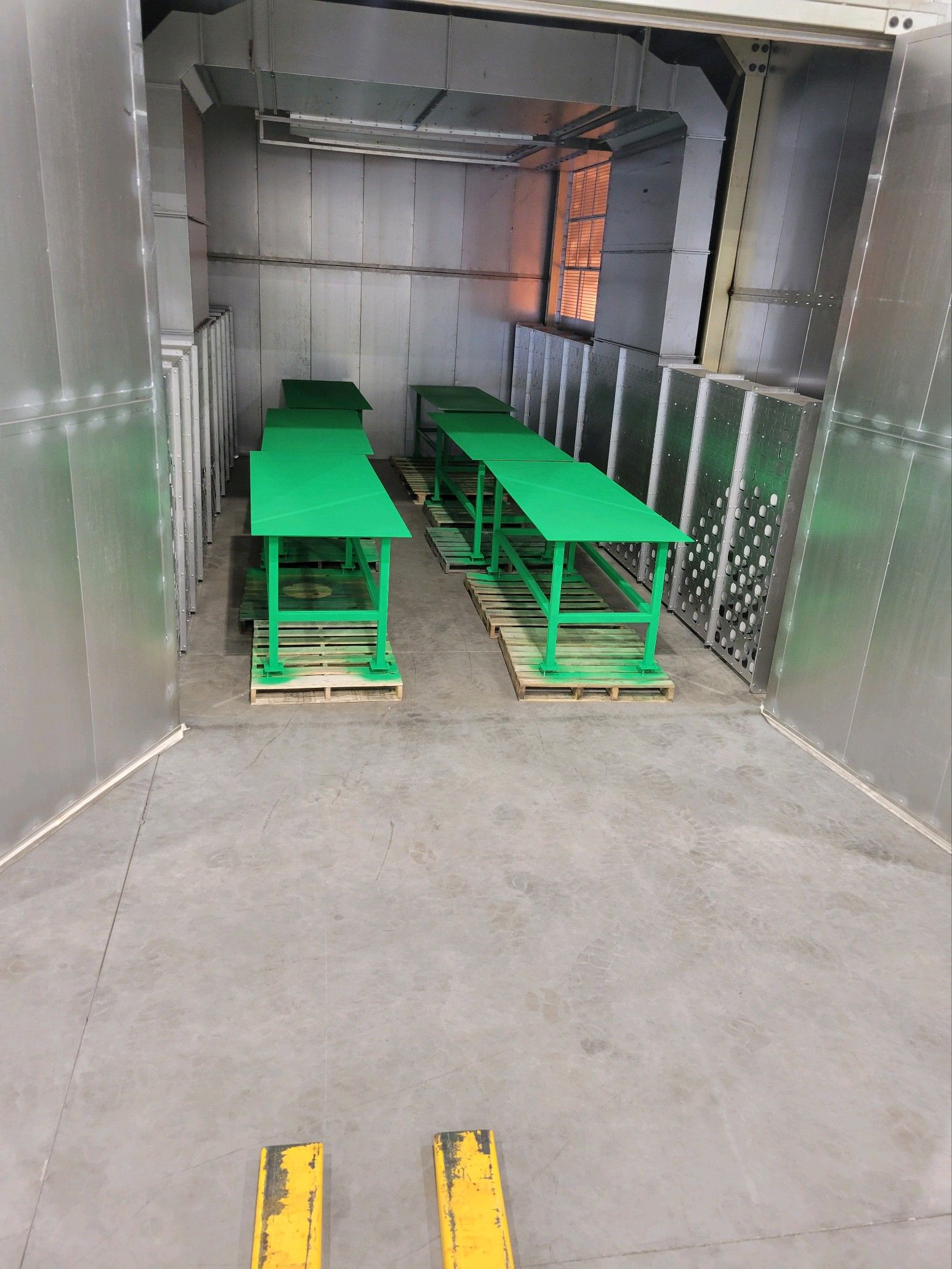 A room with a lot of green tables in it