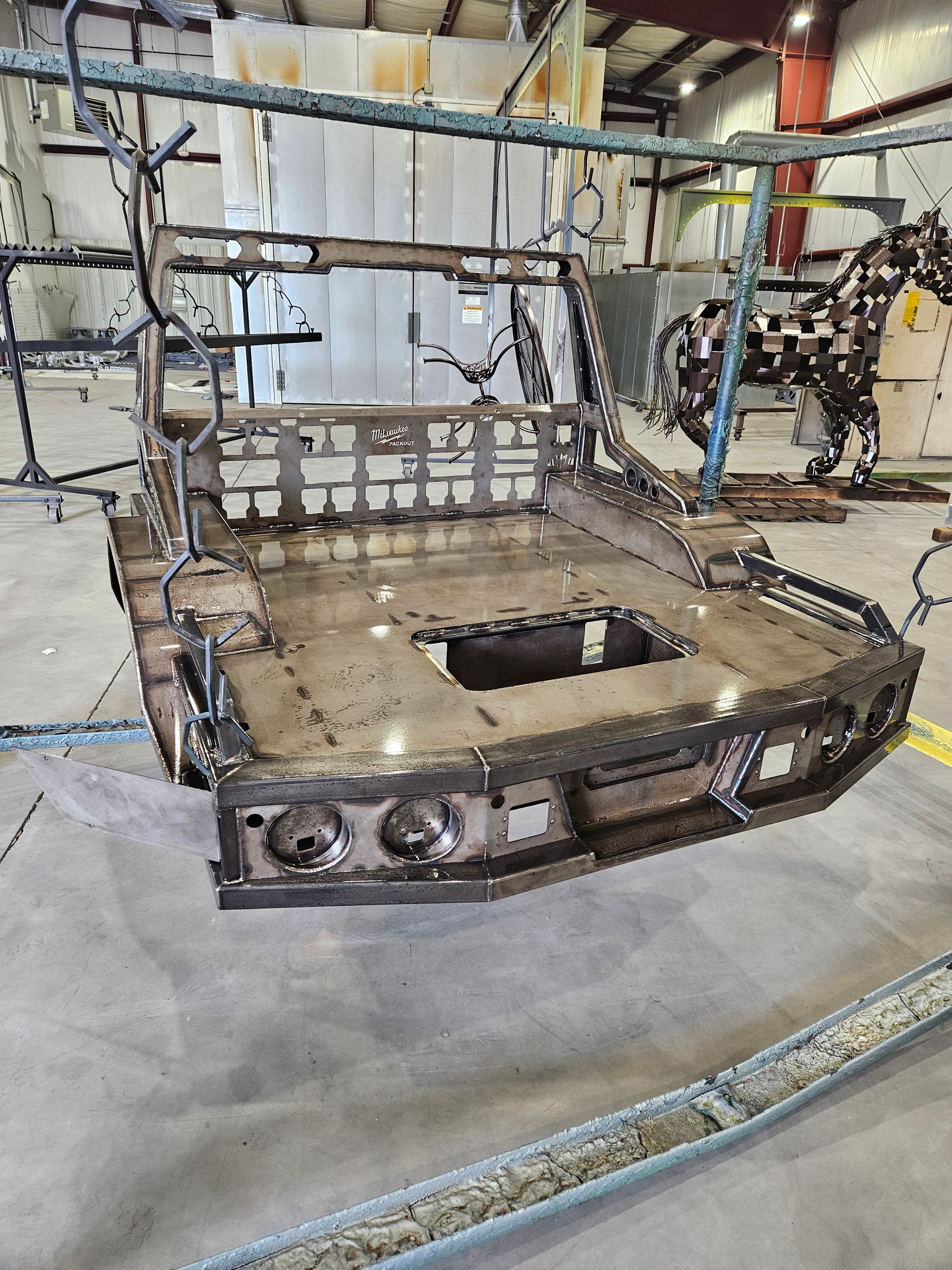 A piece of metal is hanging from a rack in a factory.
