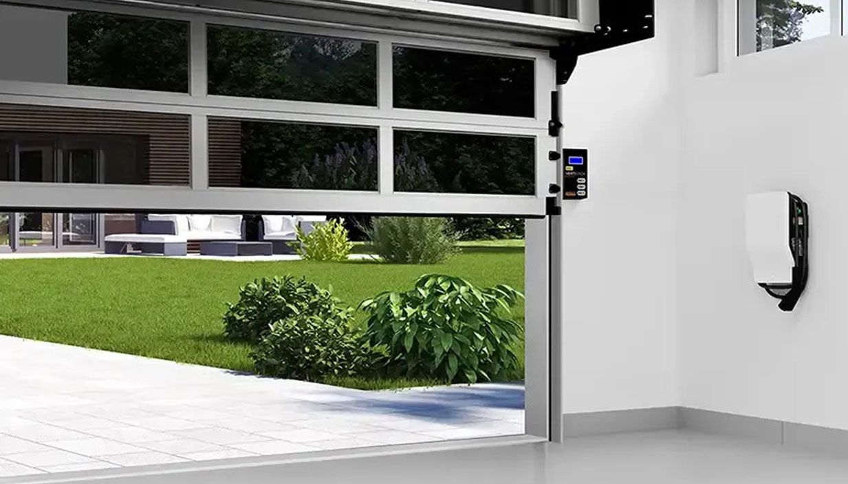 Modern garage interior with open black sectional door, wall-mounted opener, and storage shelves on the right.
