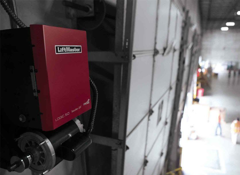 Red LiftMaster door opener mounted on a warehouse wall.