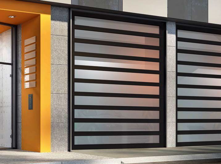 Modern building entrance with large horizontal glass doors and an adjacent yellow wall.