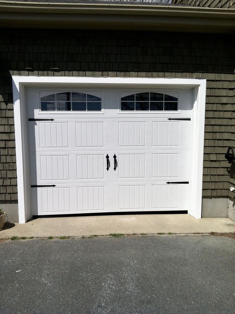 White garage door with arched windows and black hardware.