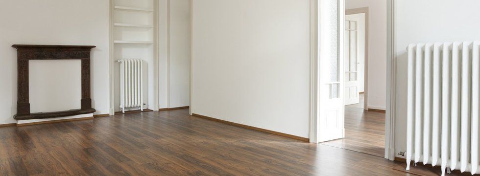 Unfurnished home with brown flooring and white wall