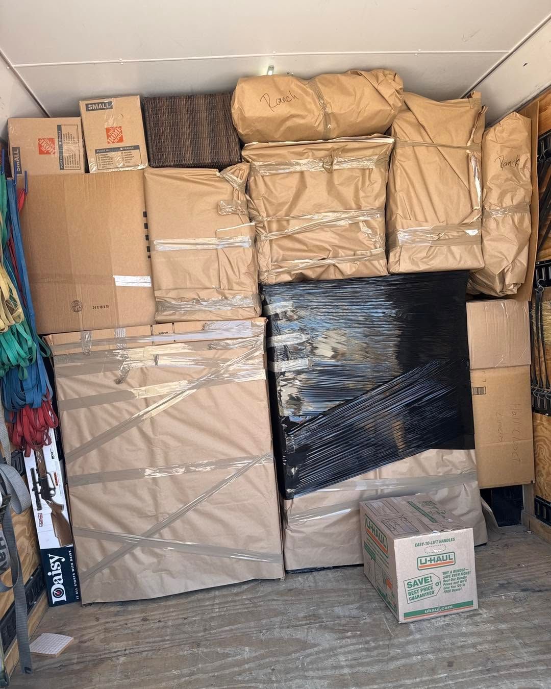Packed cardboard boxes and wrapped items stacked tightly inside a storage room.