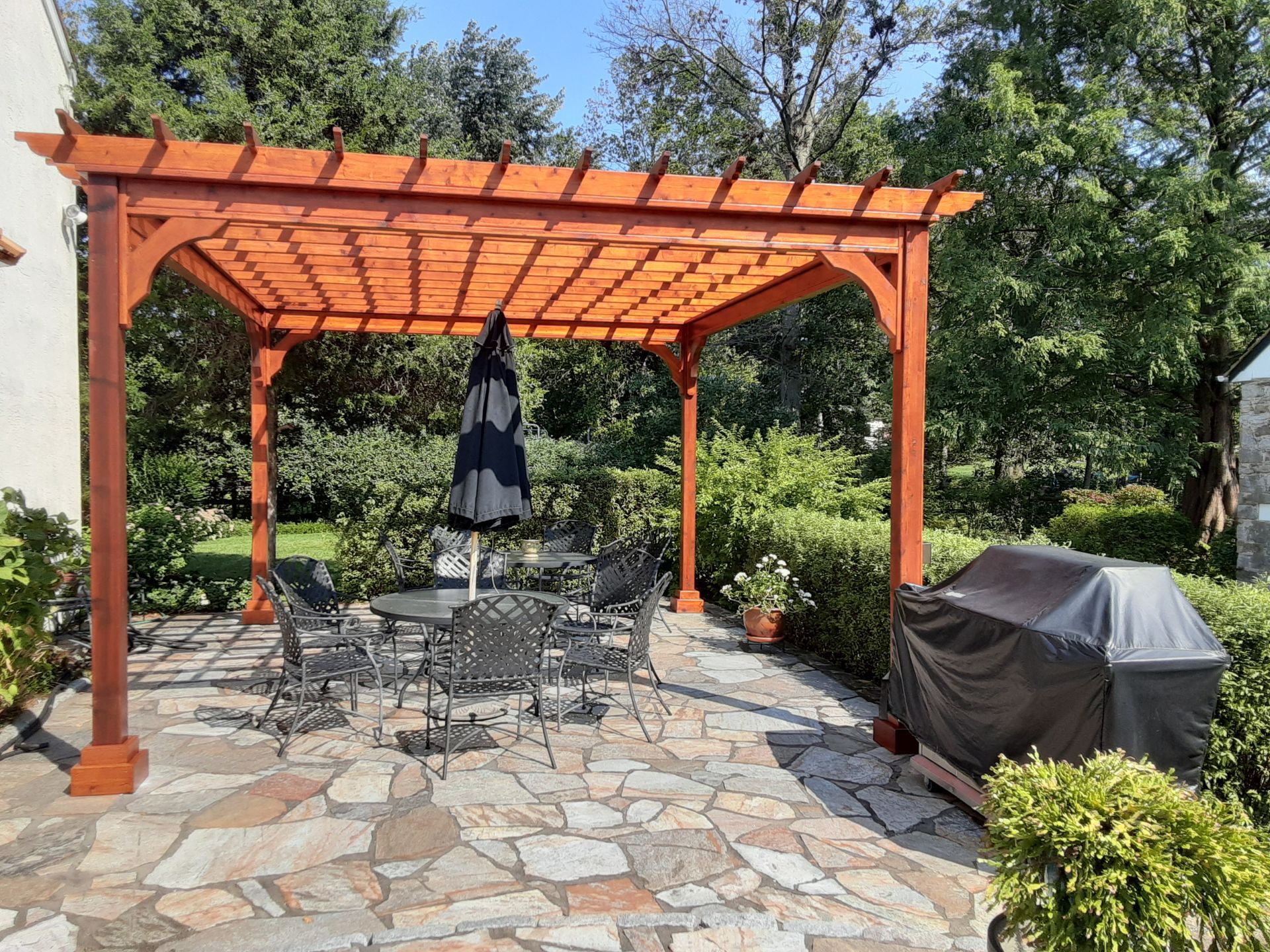 Stone patio with a wooden pergola