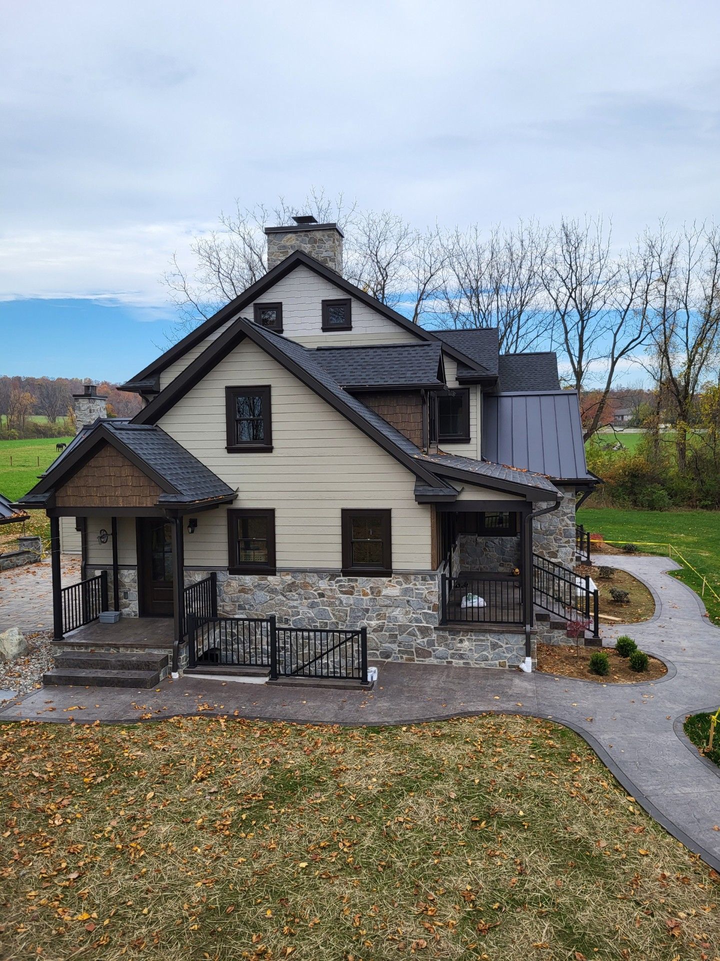 Two-story beige house with dark trim, front porch