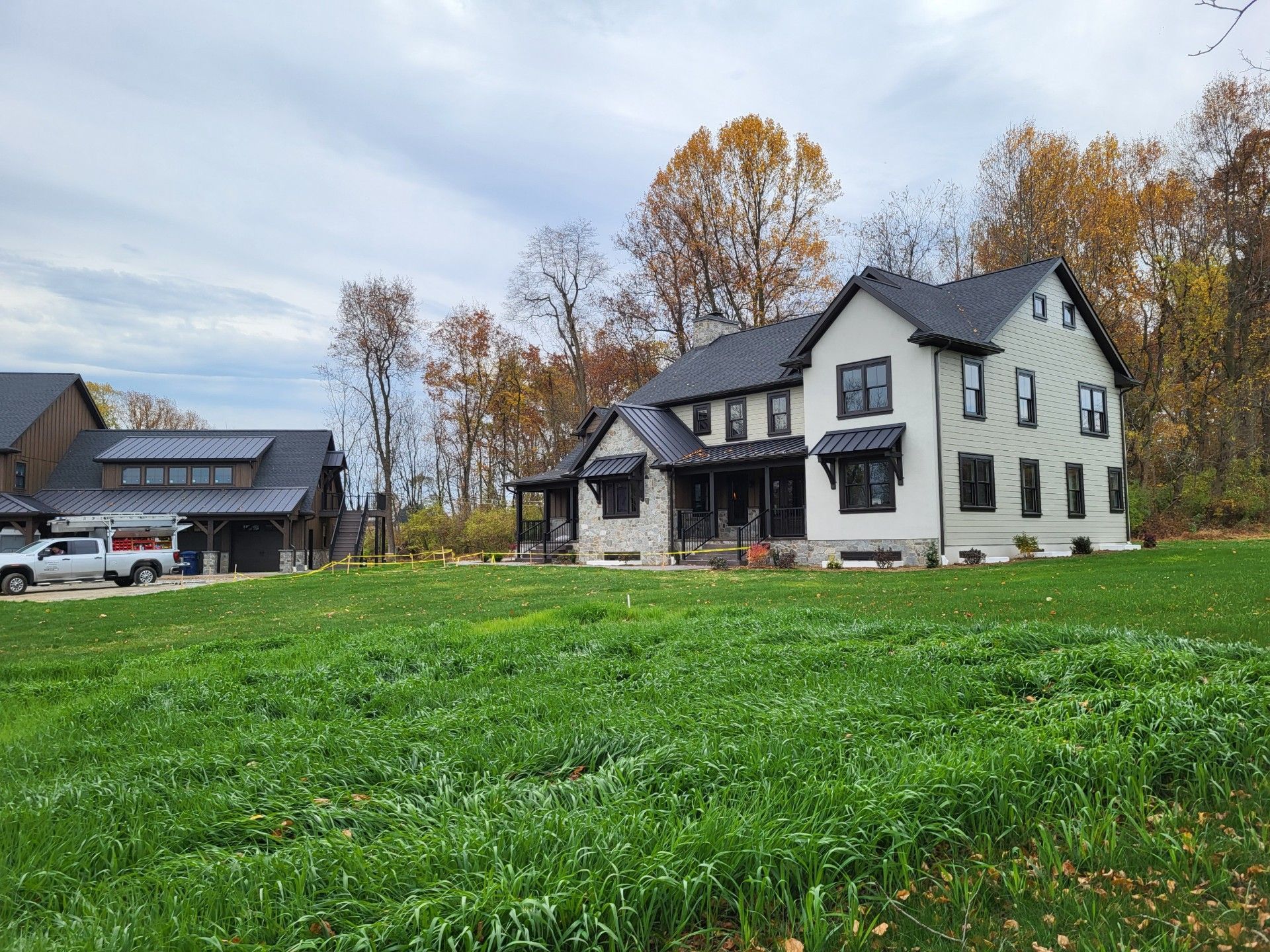 White house and barn beside a green field 