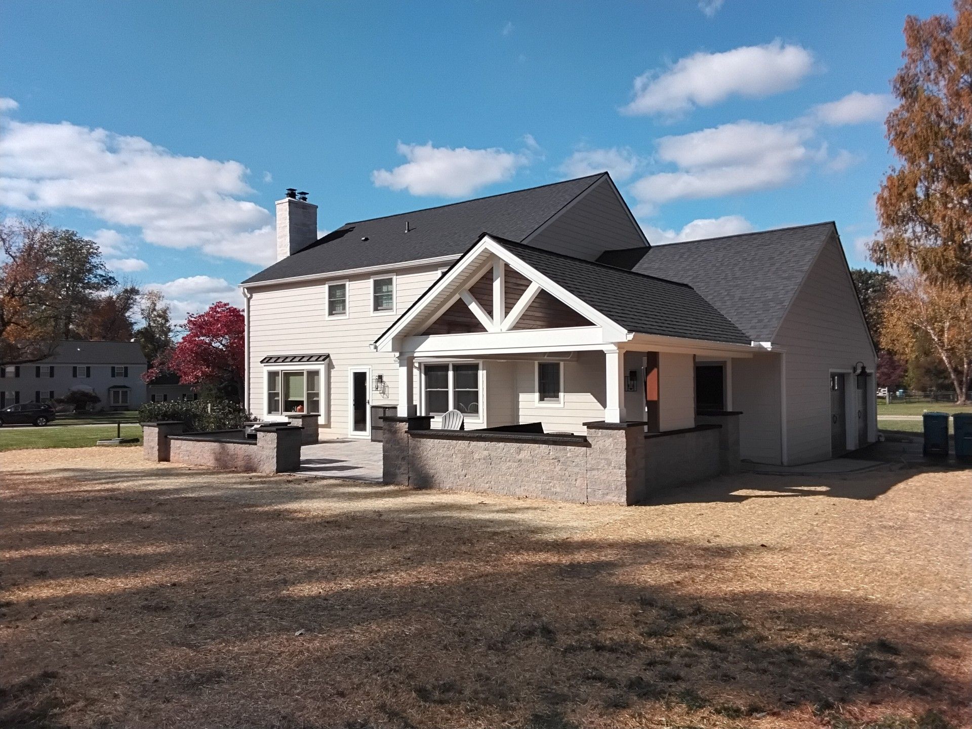 Two-story house with a porch and brick accents on a sunny day.