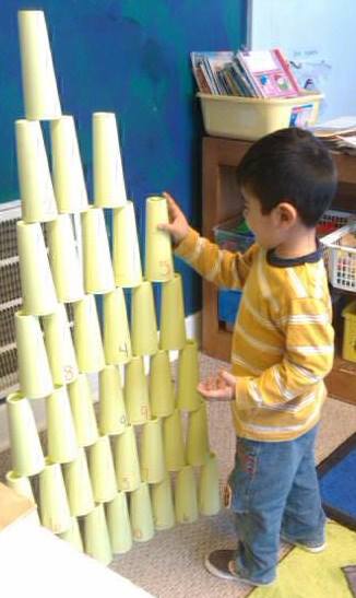 Child building a tower using cups