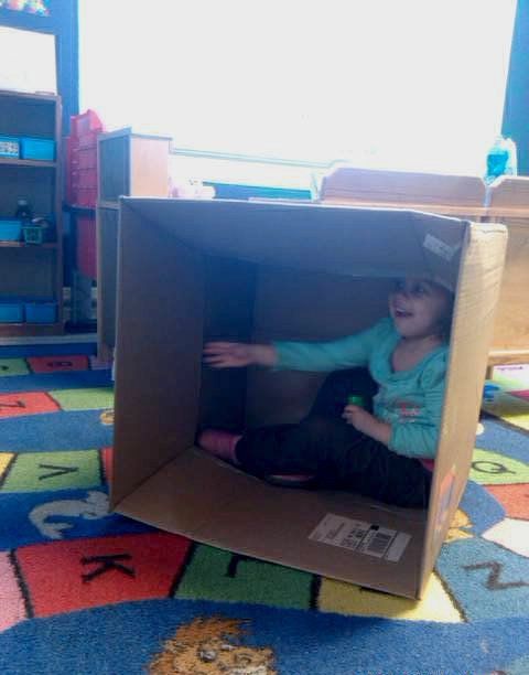 Child hiding inside a box