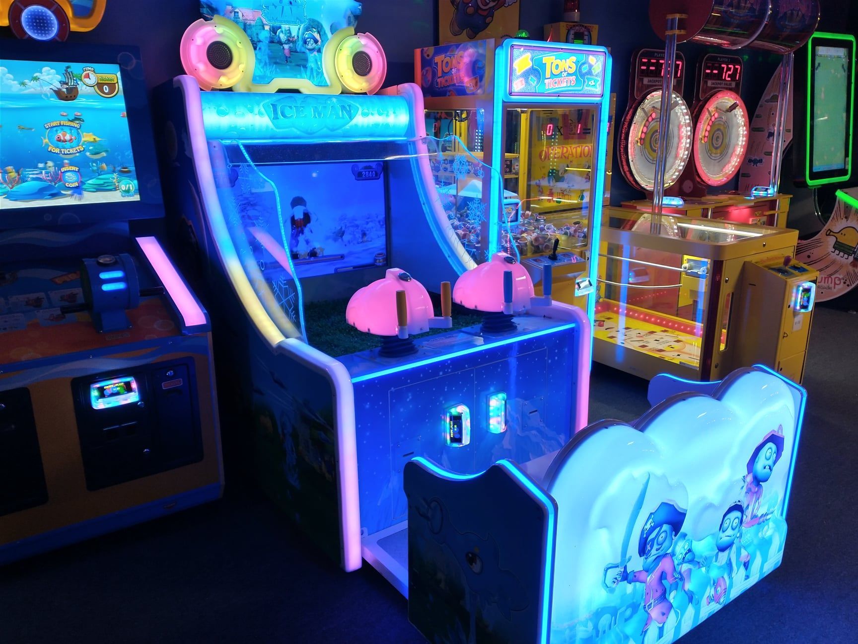 Arcade game with neon blue lights, pink gun targets, and ocean-themed graphics.