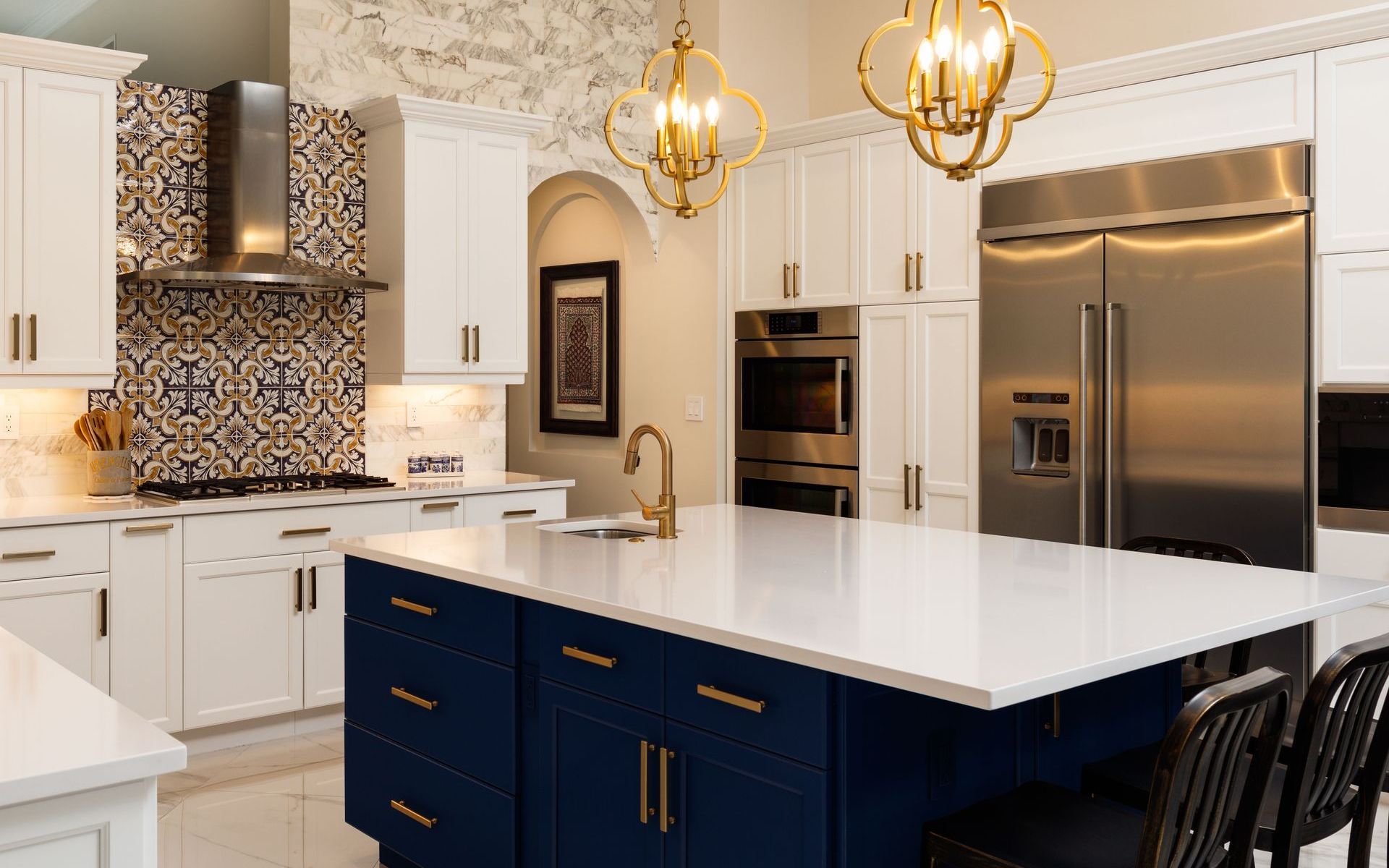 A kitchen with a large island and three stools.