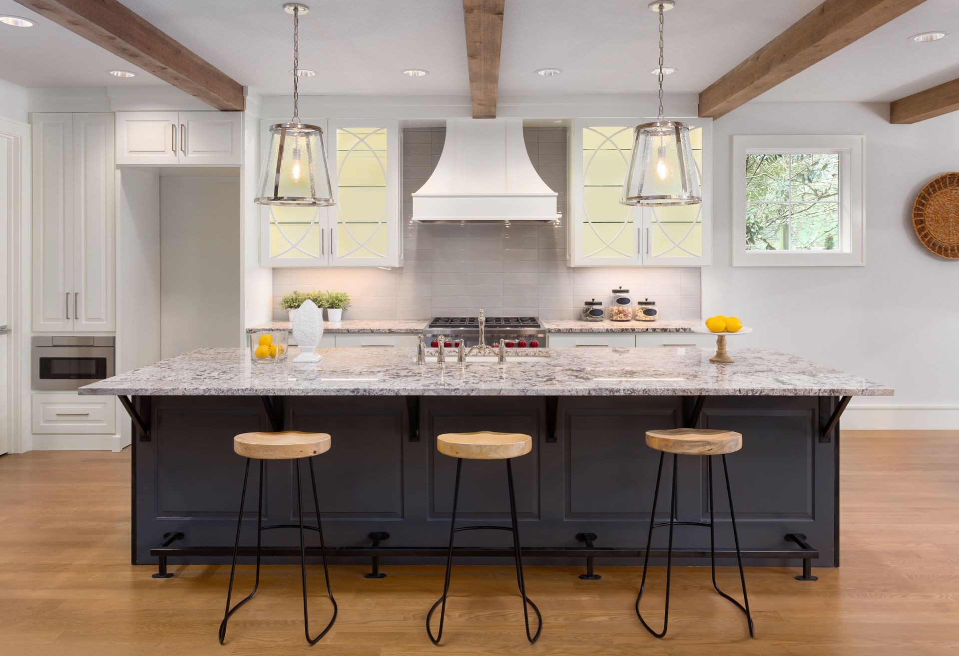 A kitchen with a large island and three stools.