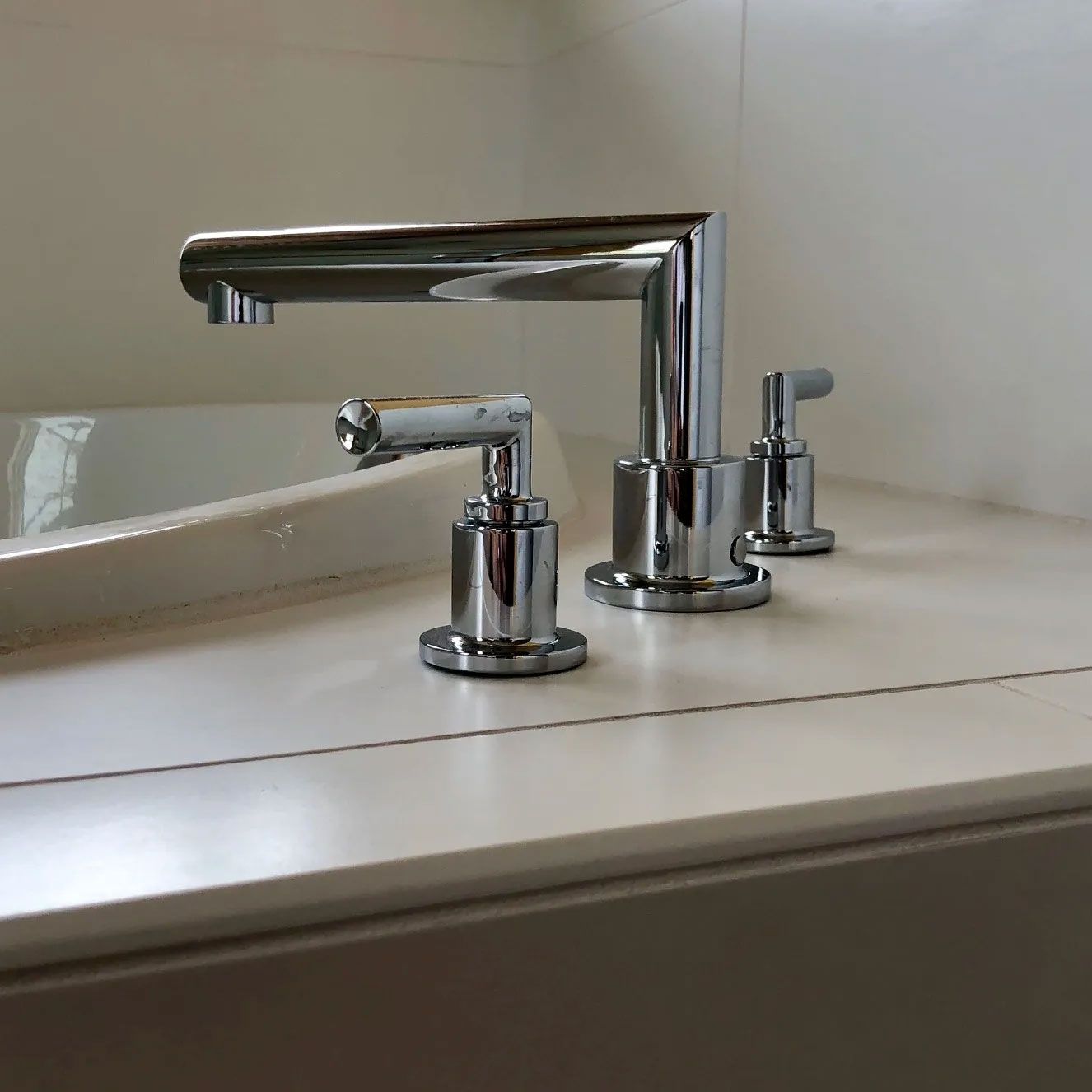 A bathroom sink with a chrome faucet and soap dispenser