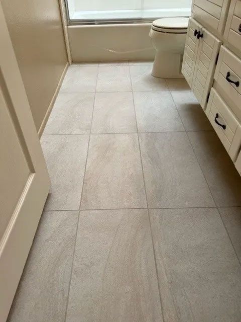 A bathroom with white tile floors and a toilet
