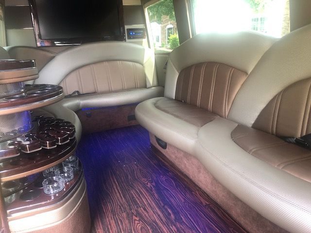 the inside of a limousine with a couch and a television