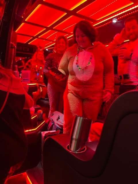 a group of people standing in a limousine bus with red lights