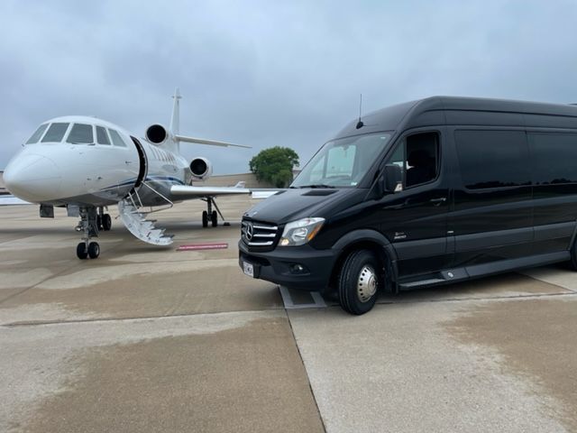 a black van is parked next to a private jet