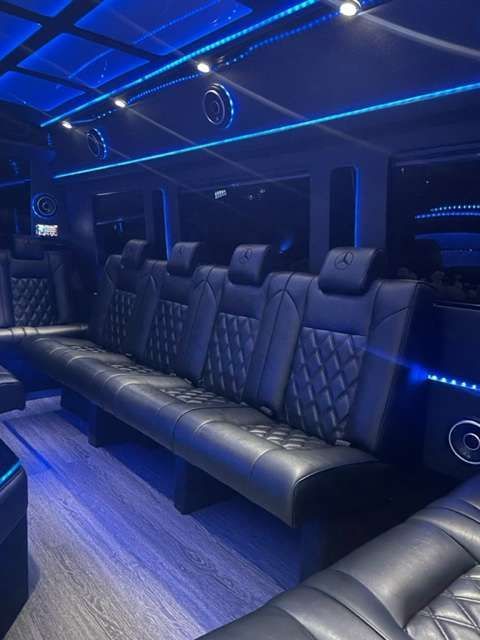 a row of black leather seats in a limousine with blue lights