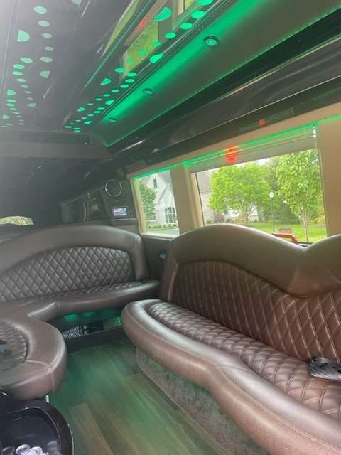 the inside of a limousine with a lot of seats and green lights