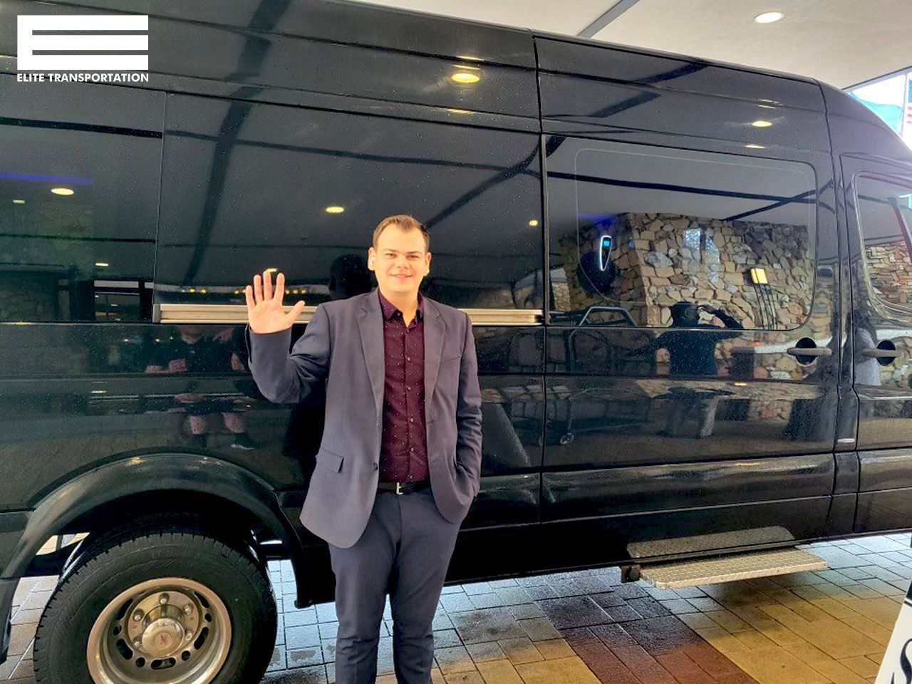 a man in a suit is standing in front of a black van