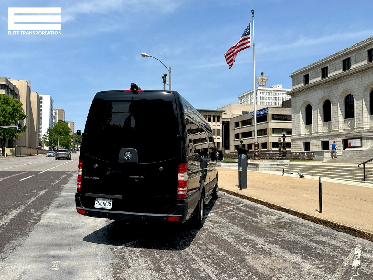 a black van is parked on the side of the road in front of a building