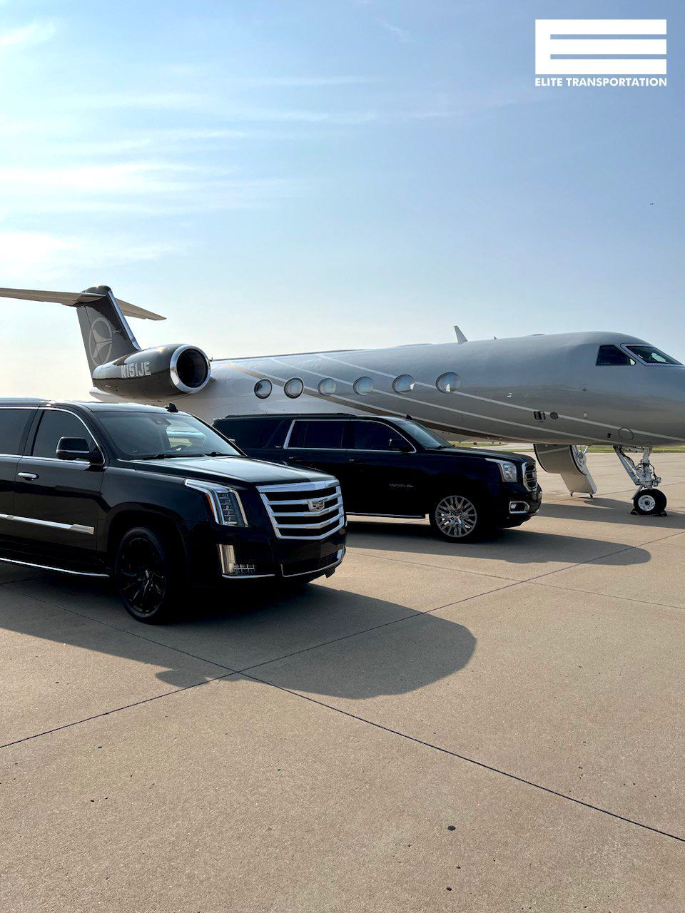 two cars are parked next to a private jet on a runway
