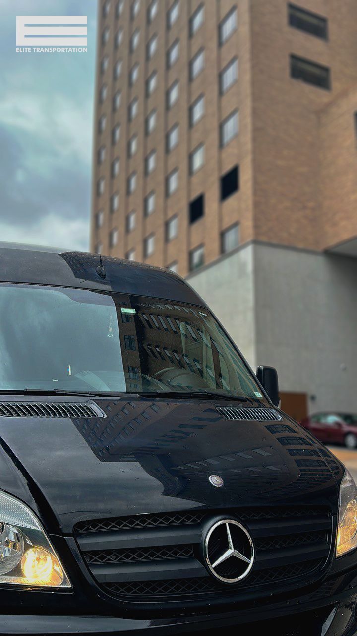 a black mercedes van is parked in front of a tall building