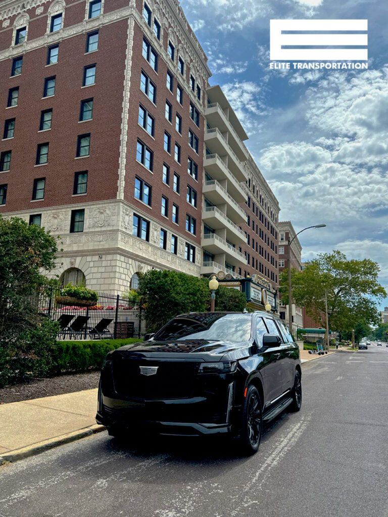 a black car is parked on the side of the road in front of a large brick building