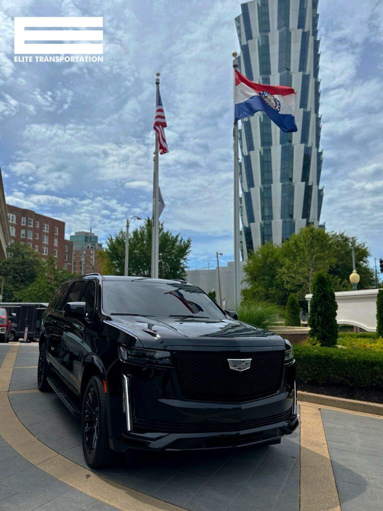 a black cadillac escalade is parked in front of a tall building