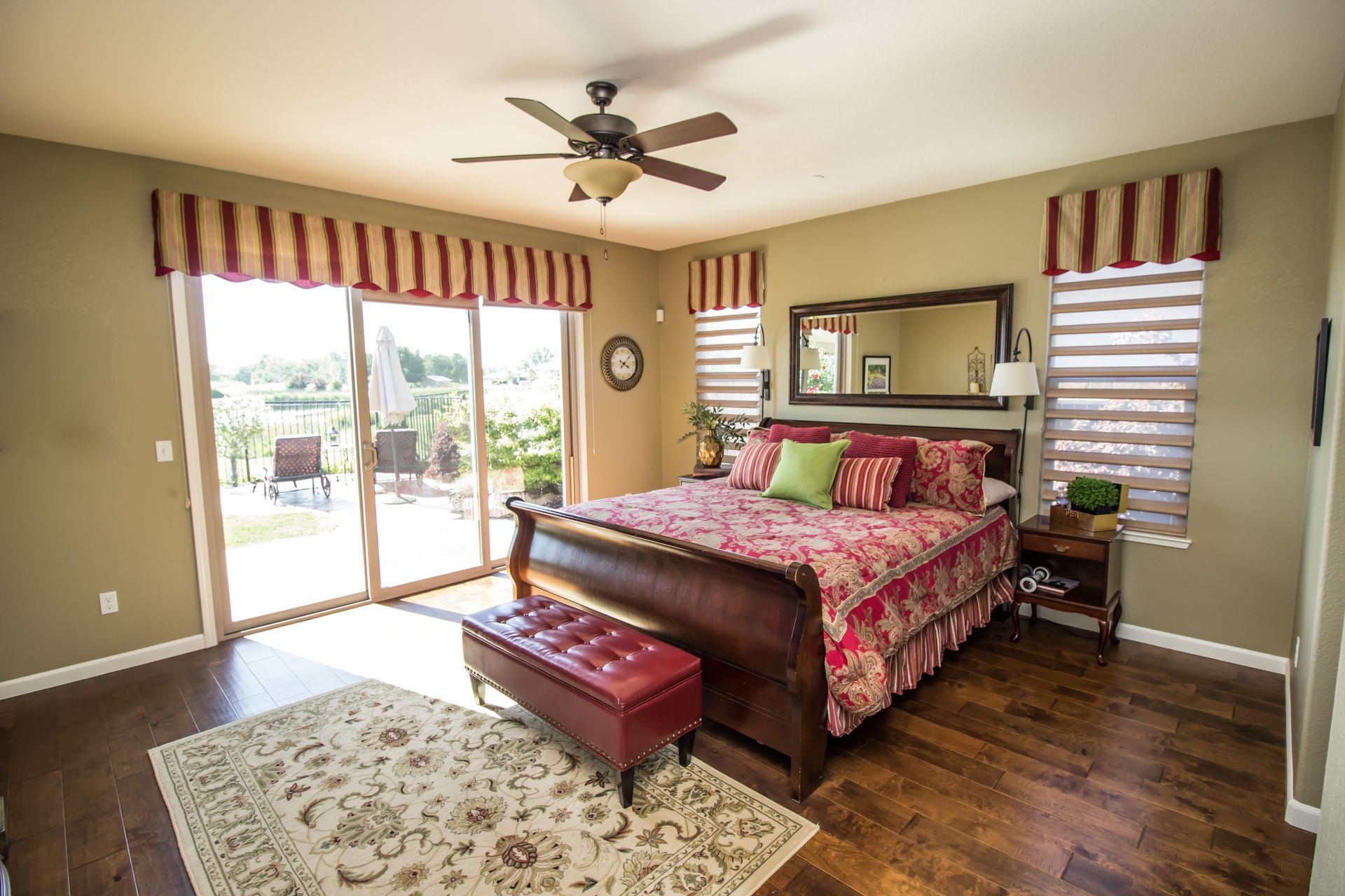 Bedroom with a large bed, sliding glass door, and red and white striped valances.