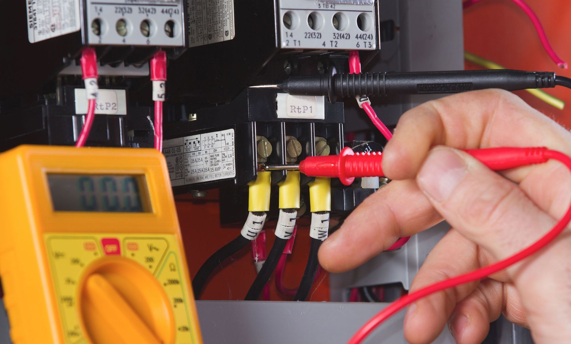 A person is using a multimeter to test an electrical circuit.