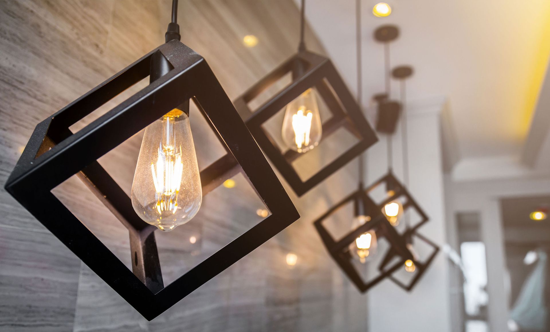 A row of pendant lights hanging from the ceiling in a room.