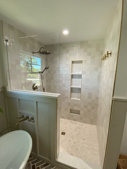 A bathroom with a walk in shower and a bathtub.