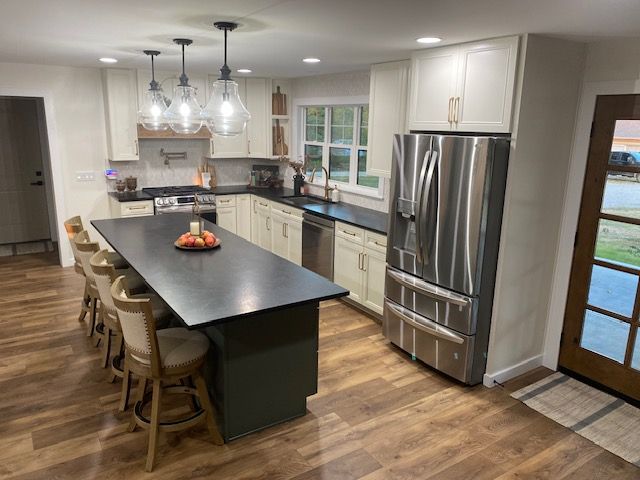 A kitchen with stainless steel appliances and a large island.