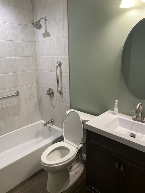A bathroom with a toilet , sink , bathtub and shower.