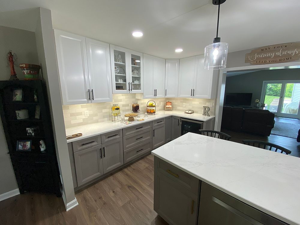 A kitchen with cabinets, white counter tops and a large island