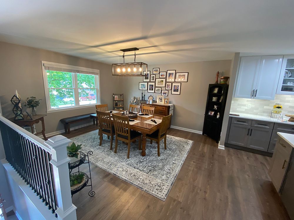 A dining room with a table and chairs and a rug