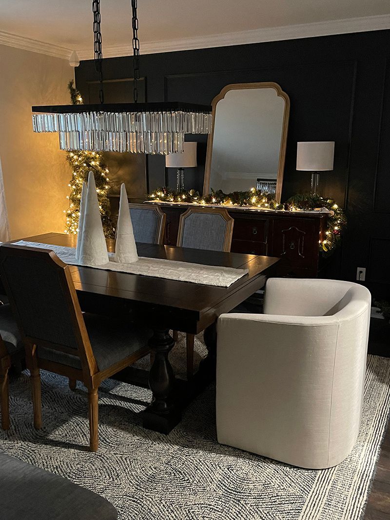 A dining room with a table and chairs and a mirror