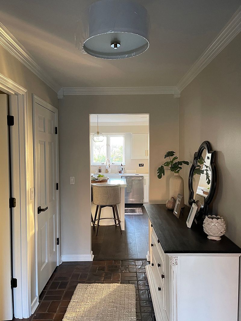 A hallway in a house with a dresser and a mirror